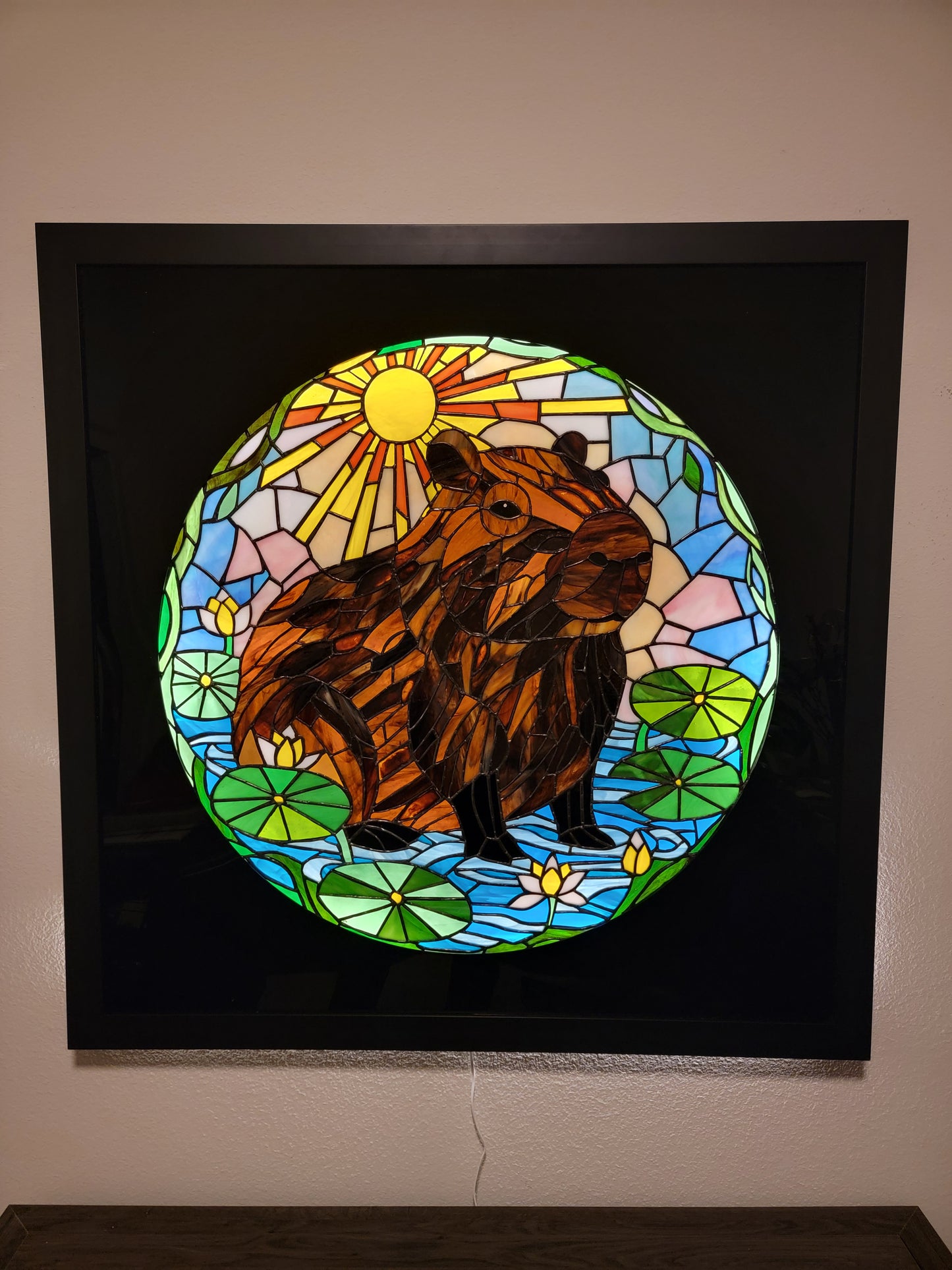 Striking handcrafted stained glass features a serene capybara resting in a pond